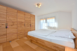 Elternschlafzimmer - mit Zugang zum Balkon und grossem Holzkleiderschrank